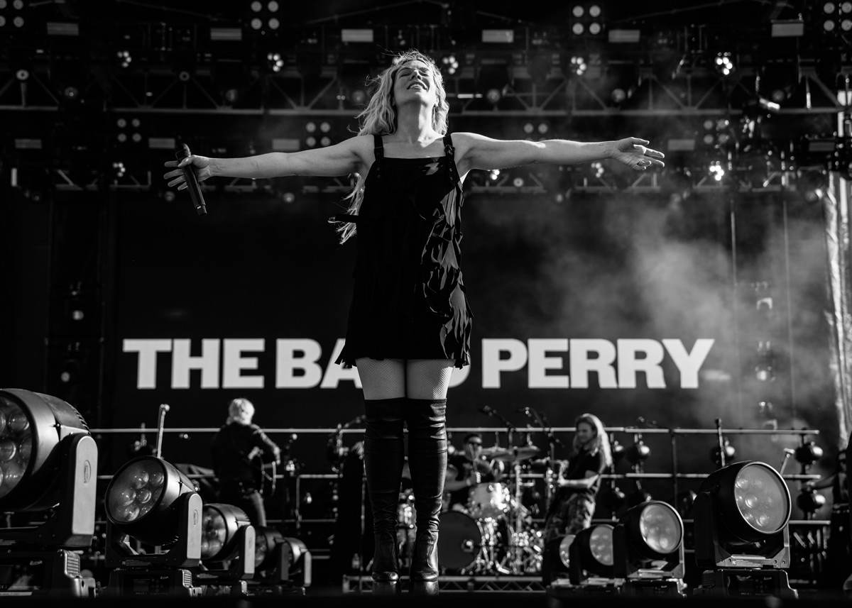 black and white photo of woman on a stage with microphone.